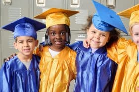 New Horizon Academy pre-kindergarten graduates wearing graduation caps and gowns and getting ready for kindergarten