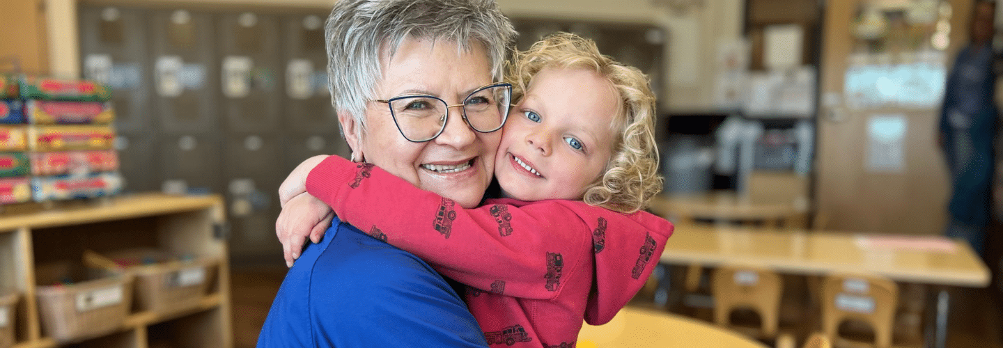 Preschool teacher hugging preschool student at New Horizon Academy