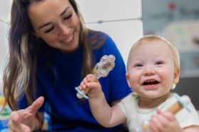 Infant teacher playing with infant at daycare